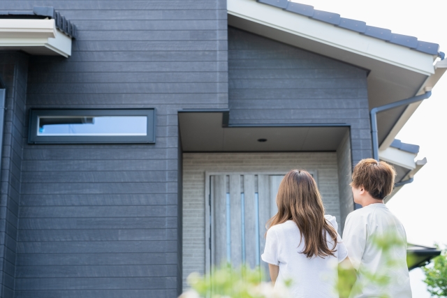 戸建てを見つめる家族